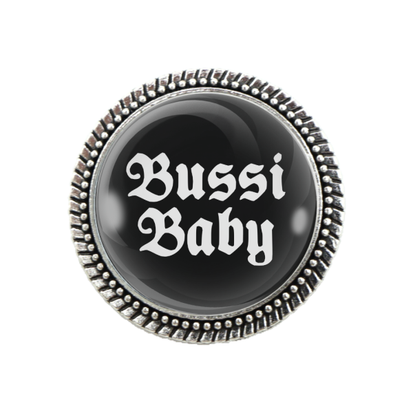 Nahaufnahme der humorvollen Gaudibrosche mit dem Spruch „Bussi Baby“ – perfekter Trachtenschmuck