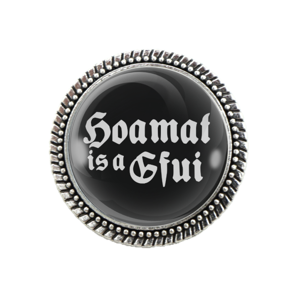 Schwarze Trachtenbrosche mit Spruch „Hoamat is a Gfui“ in silberner Fassung
