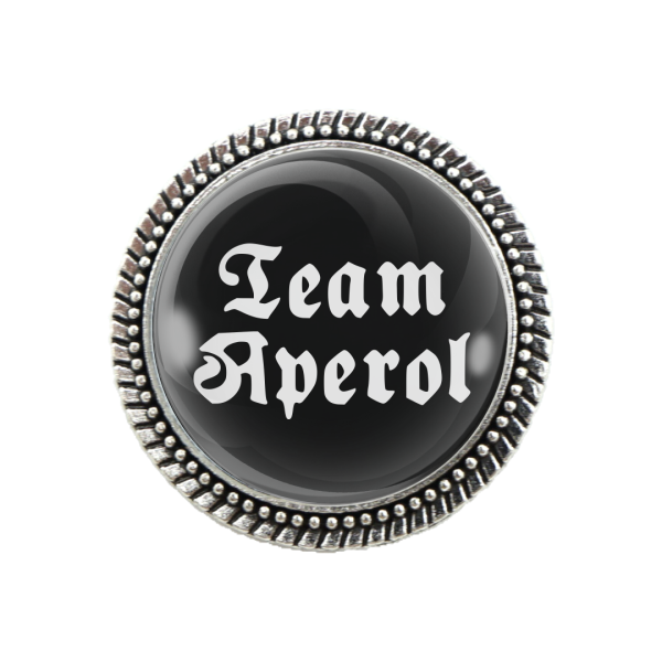 Pracht-Gaudibrosche „Team Aperol“ auf schwarzem Hintergrund mit silberner Fassung