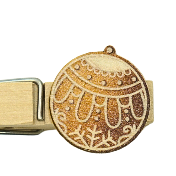 Nahaufnahme der Holz-Namensklammer mit "Lebkuchen Christbaumkugel" Motiv und Handgravur.